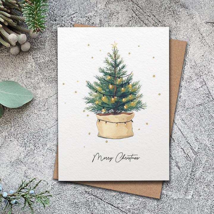 a card with a christmas tree in a pot