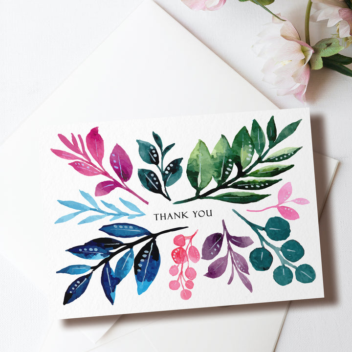 a thank you card with watercolor leaves on it