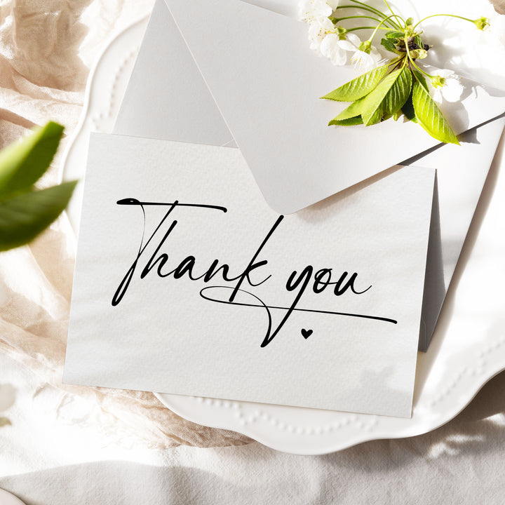 a thank you note sitting on top of a white plate