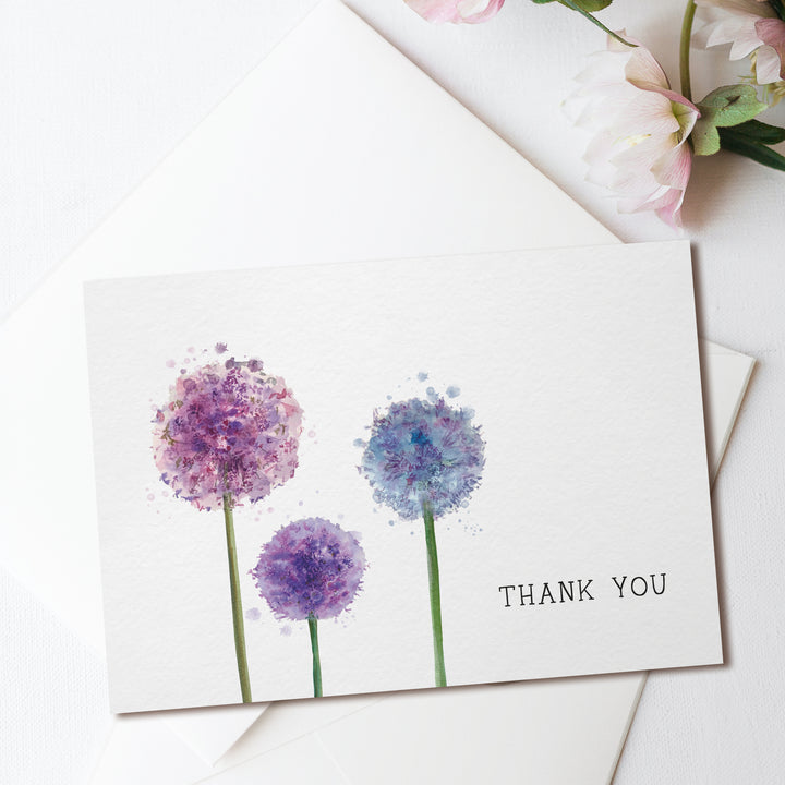 a thank you card with three purple flowers