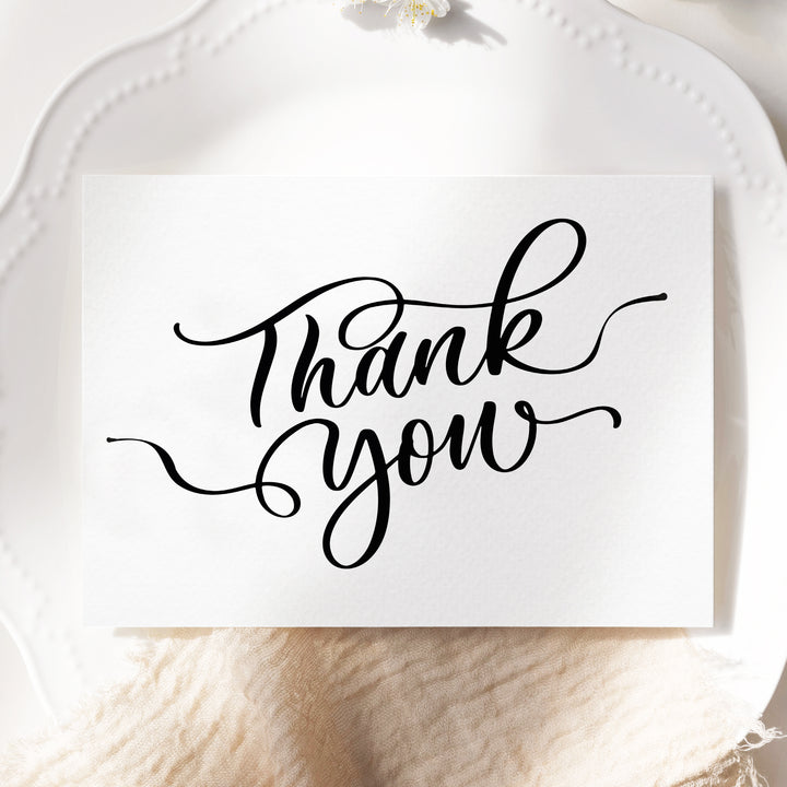 a white plate topped with a card that says thank you