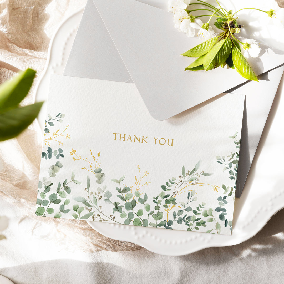 a thank you card on a plate with flowers