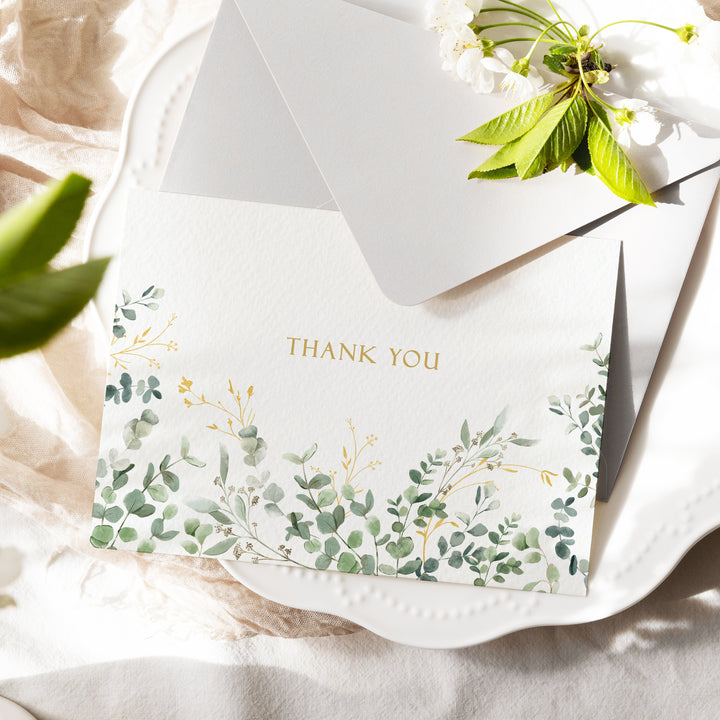 a thank you card on a plate with flowers