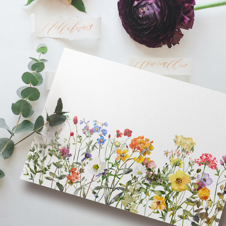 a card with flowers on it next to a plant