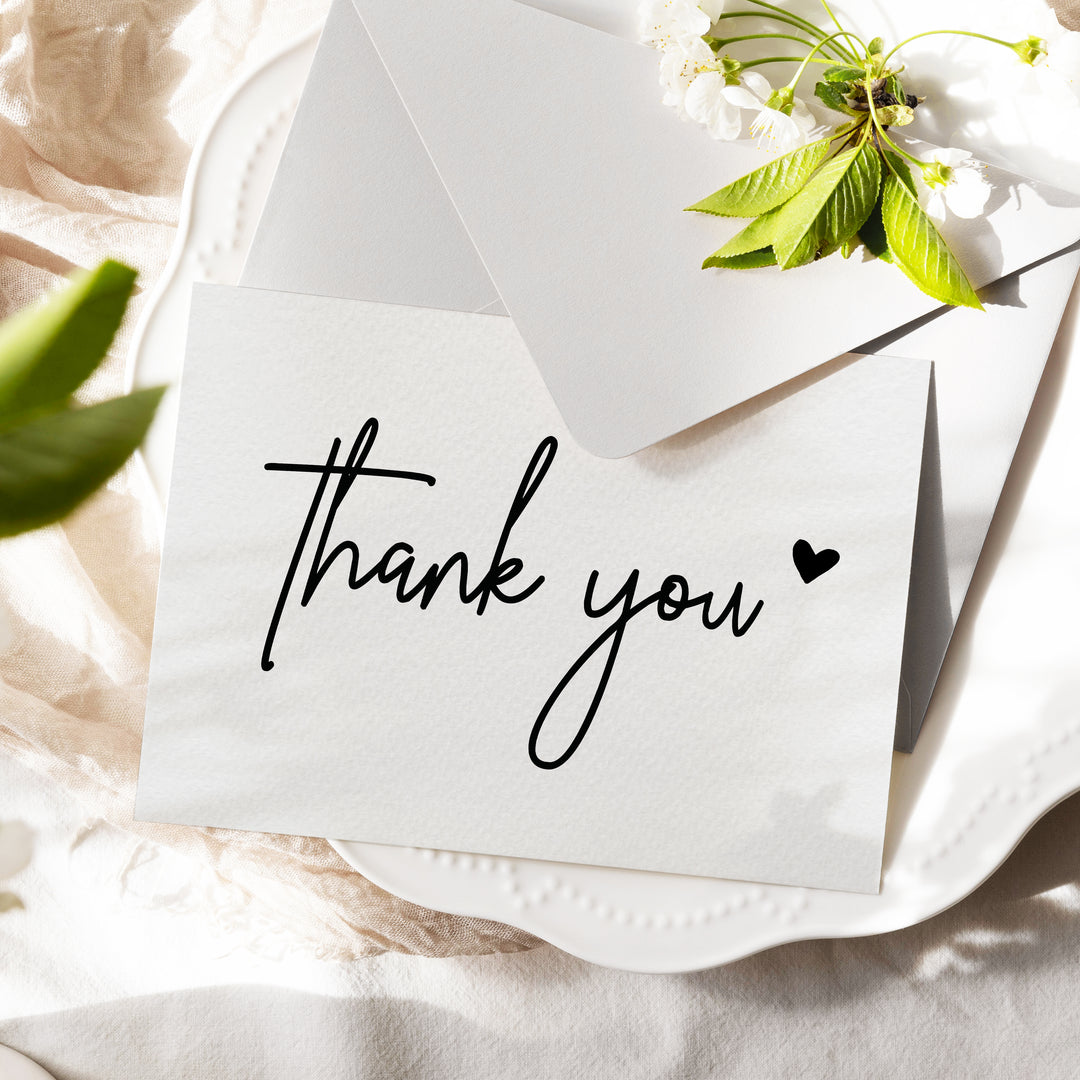 a thank you note sitting on top of a white plate