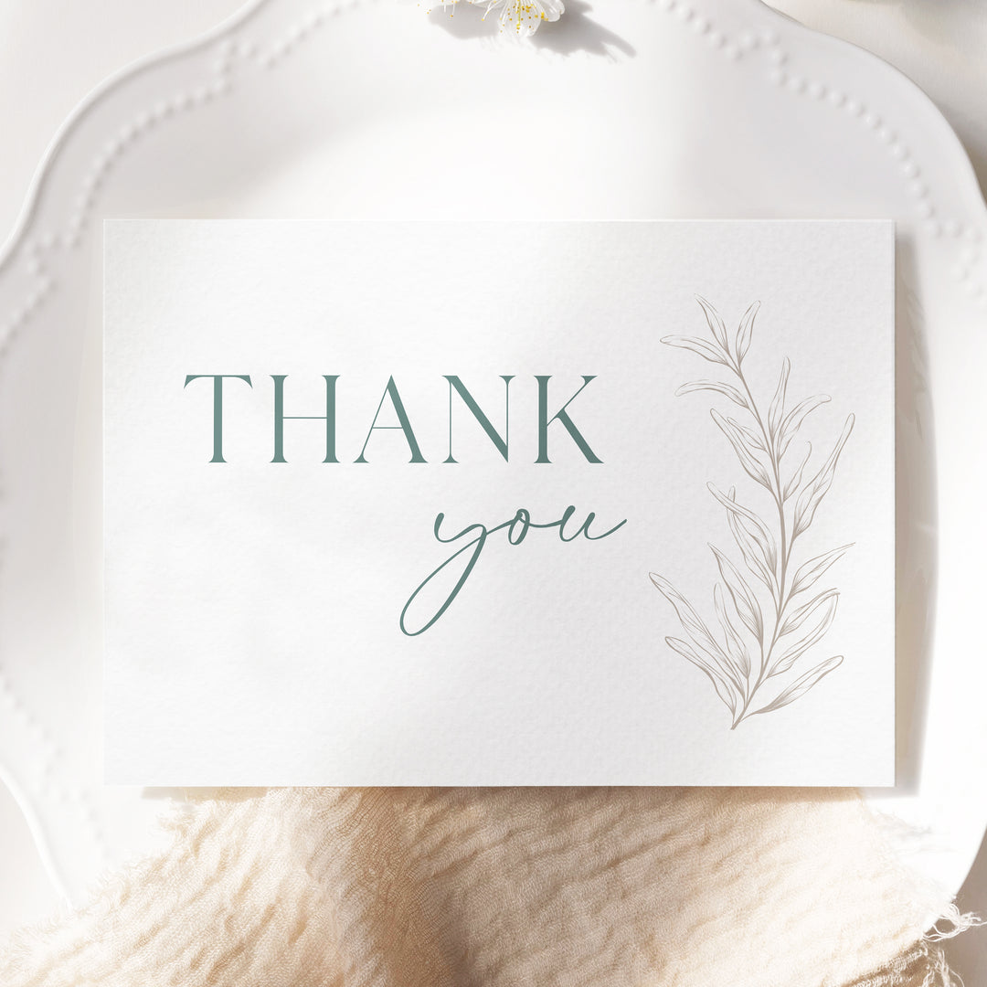 a thank you card sitting on top of a white plate