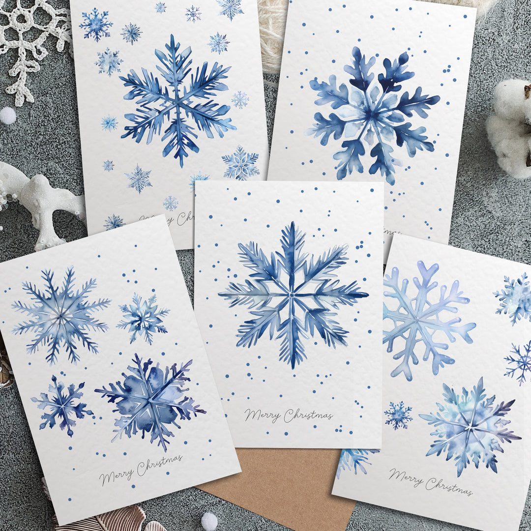 four blue snowflakes on white cards on a table