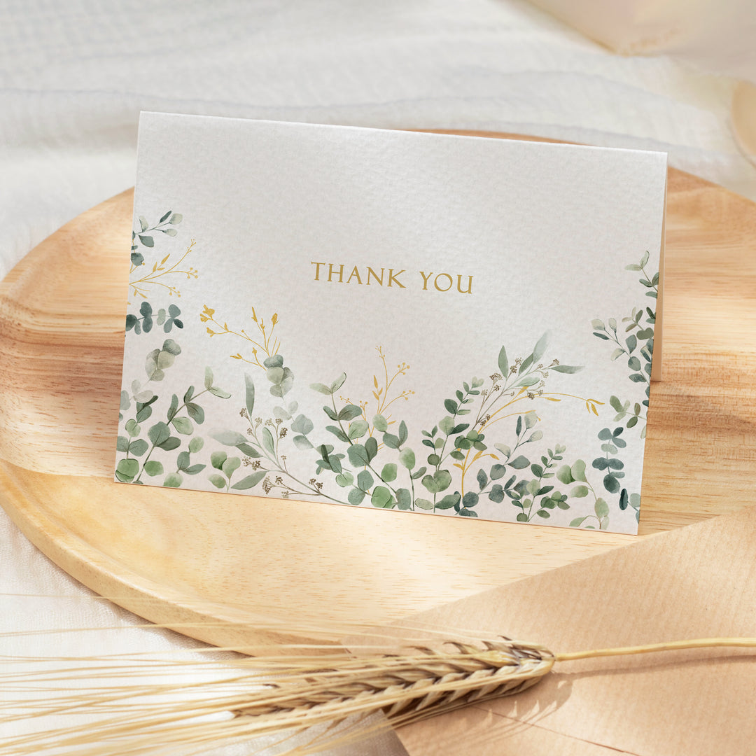 a thank you card sitting on top of a wooden plate