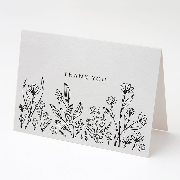 a thank card with black and white flowers