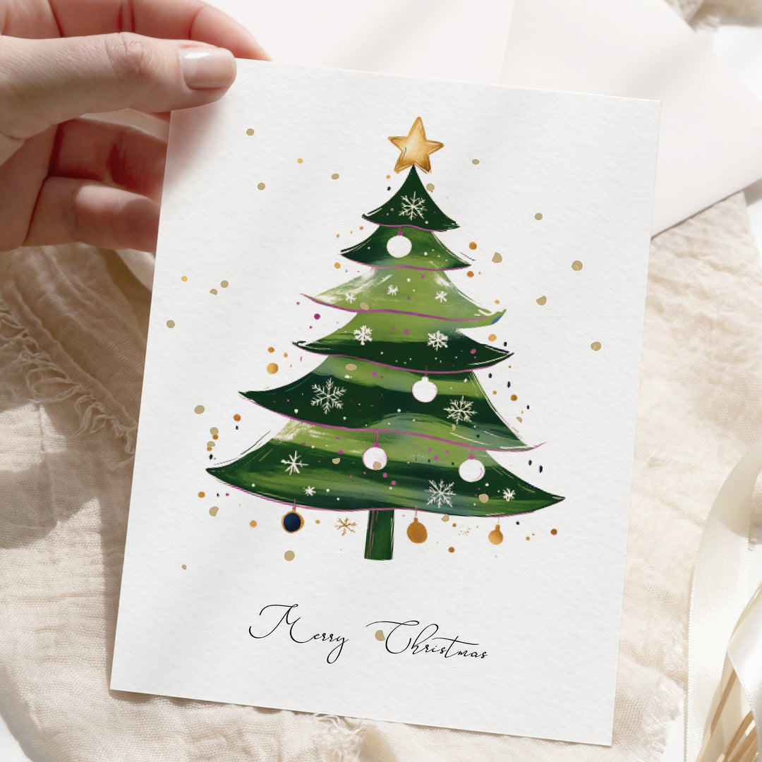 a hand holding a card with a christmas tree on it