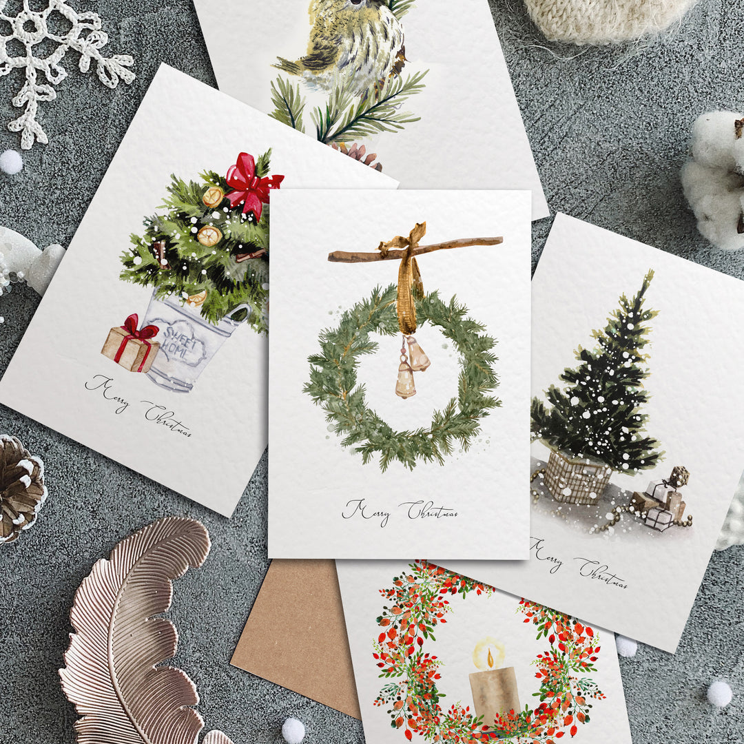 four christmas cards on a table with christmas decorations