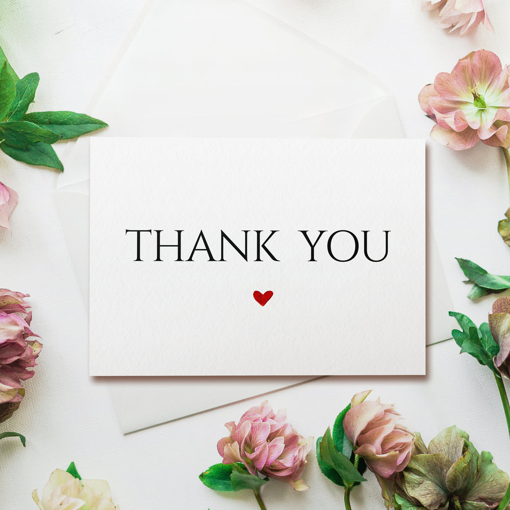 a thank you card with a red heart surrounded by flowers