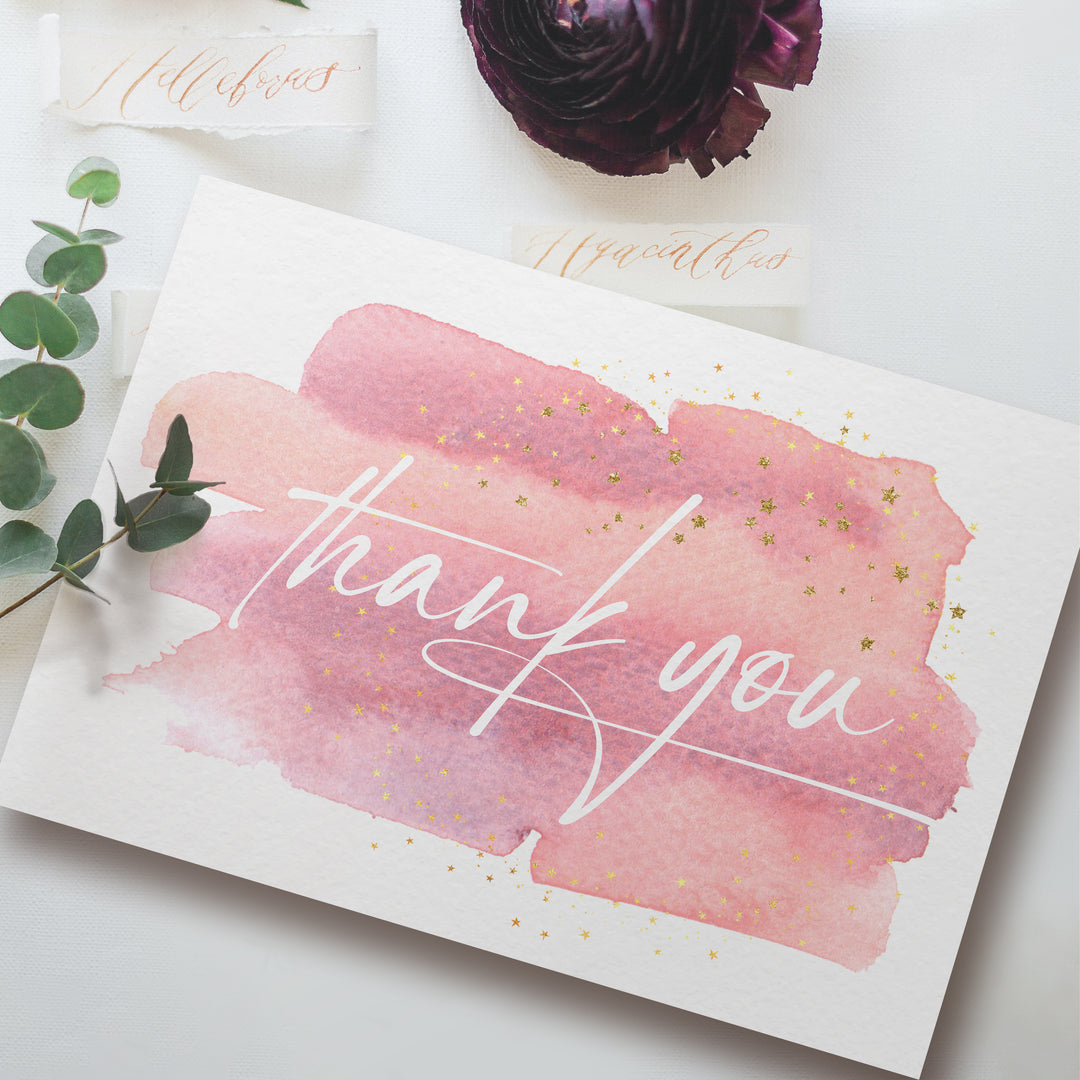 a thank you card on a table with flowers