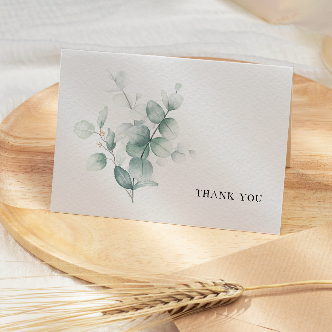 a thank you card sitting on top of a wooden plate